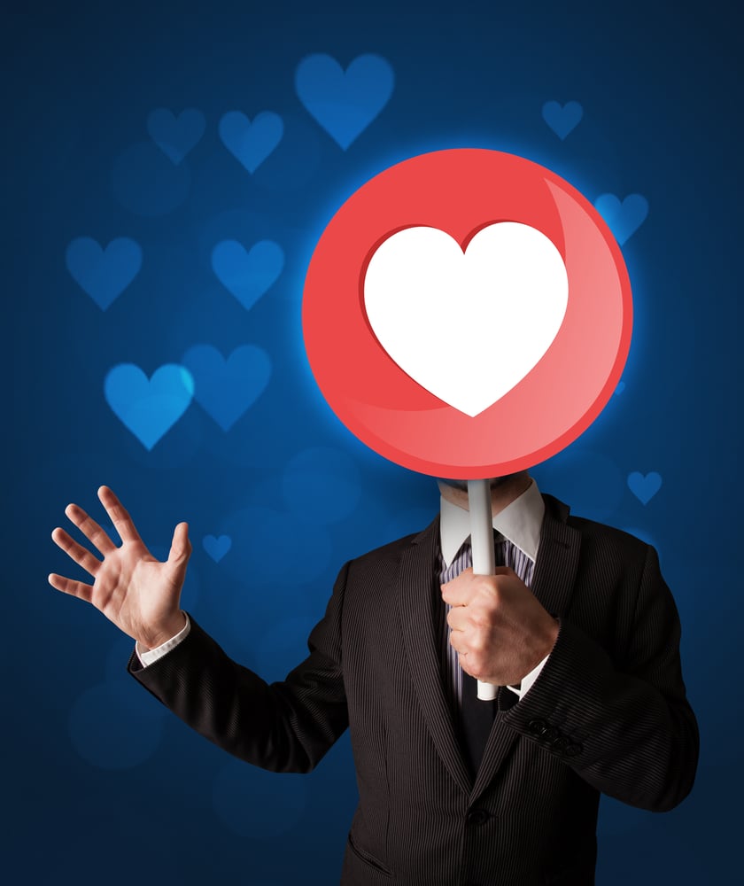 Smart businessman holding round sign with heart